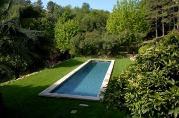 Ce bassin de nage est installé sur l'une des terrasses d'un terrain en restanque et s'intègre avec une sobriété et une discrétion parfaite dans la demeure.