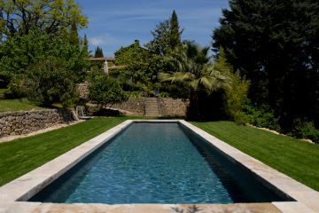 Posé au milieu d'un gazon parfaitement entretenu, ce bassin de nage est comme un grand tapis d'eau qui apporte autant par le plaisir de la nage que celui de la contemplation et apporte un esprit zen à la maison.