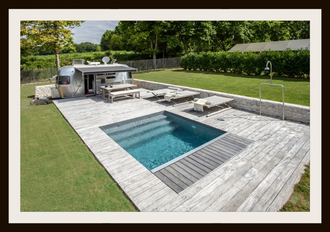 Piscinelle d'Or 2020 - Petite piscine carrée au design abouti et surprenant avec la caravane Airstream® en guise de poolhouse. 