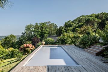 Une fois le rideau immergé fermé, la piscine est sécurisée. La couleur du tablier du volet est choisie pour être en cohérence avec l'ensemble du projet piscine.