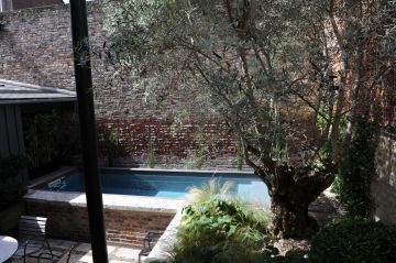 Techniquement hors-sol la piscine est rhabillée d'un mur en brique pour rester en parfaite harmonie avec le décor typique de cette maison du centre historique de Rouen.