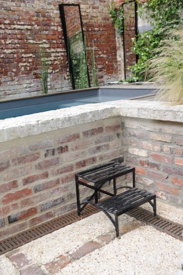 Pour accéder à la piscine, un petit escalier métallique répondant aux poutrelles et IPN de la cour est soigneusement disposé au pied du muret de brique qui ceint la Piscinelle.