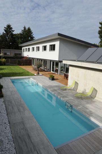 A lap pool with a stone patio