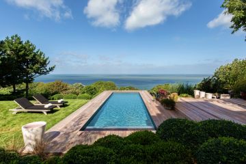 To the left, the choice of thick grass complements the sometimes tumultuous, changing skies, while to the right several levels of ipe decking provide multiple spaces to be used at different times of the day. A simple and perfectly proportioned pool takes centre stage.