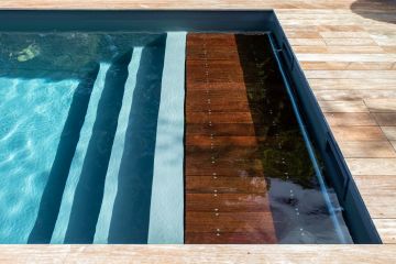 The top step of the submerged step unit includes wooden slats concealing the pool's automatic safety cover. This space-saving, discrete solution just goes to show that luxury lies in the details.