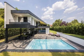 Grande piscine dans une maison contemporaine avec un carrelage imitation bois.