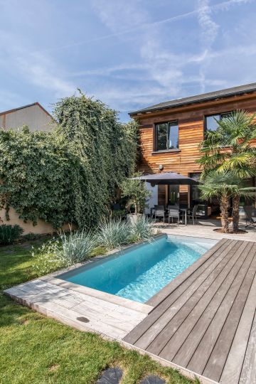 Les terrasses de la piscines résonnent avec le bardage bois de la maison et contribuent à créer l'harmonie dans ce projet.