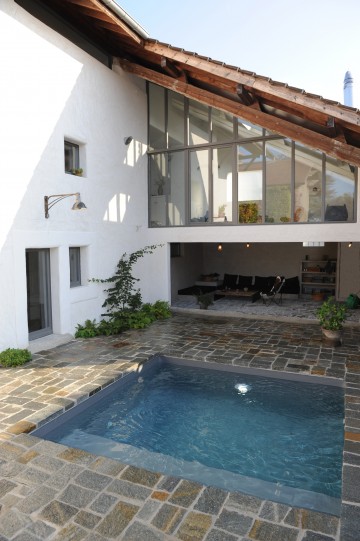 Petite piscine dans une cour intérieur avec abords en pierre naturelle