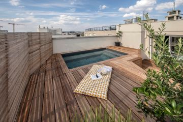 Les claustras en bois font comme une ombre projetée de persienne qui s'aligne et qui s'allonge sur la terrasse tout au long de la journée et de la course du soleil.