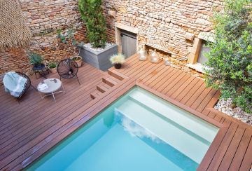 Les différents niveaux de terrasses sont accueillants et le souci du détail fait de cette petite piscine en kit un modèle d'intégration.