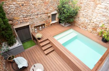 Une Piscinelle sur-mesure avec un liner vert argile et un mur filtrant en inox.