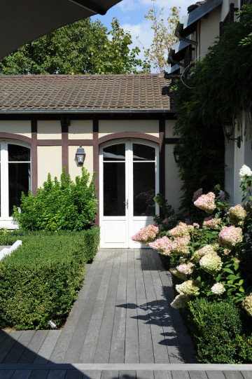 En toute sobriété, la terrasse en ipé accueille buissons taillés, hortensias et autres graminées.