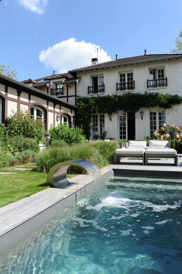 La lame d'eau donne une dynamique à la piscine et une tonalité au jardin...