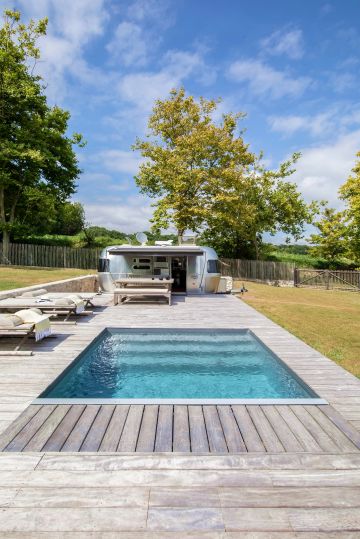 L'espace piscine est tout en variations de gris : l'ipé argenté, la caravane Airstream en inox, le mobilier extérieur et jusqu'au le liner gris ardoise qui donne presque des tons métalliques à l'eau de la piscine.