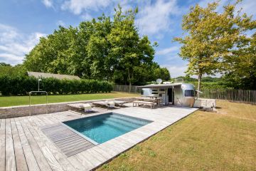 La Piscinelle est équipée d'une couverture automatique immergée. On la devine au premier plan sous le caillebotis en ipé. Ici les dimensions de la piscine ont été adaptées pour que le plan d'eau final soit bien un carré parfait et que le volet n'empiète pas sur l'espace utile de la piscine.