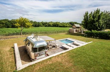 A summer heatwave has left its mark here, with dry grass due to hours of blazing heat, silvery flecks forming on the wood, and a caravan straining at the leash for its next trip.