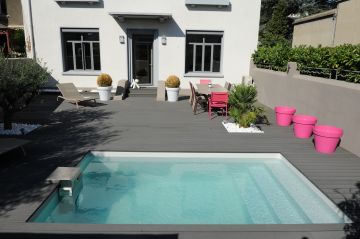 Petite piscine avec une terrasse en composite gris ardoise pour un rendu design.