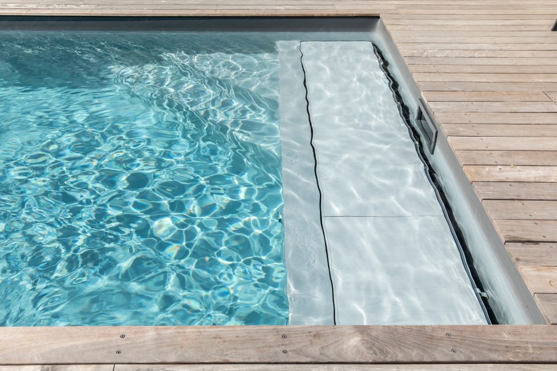 Couverture automatique de piscine de sécurité immergée sous banquette.
