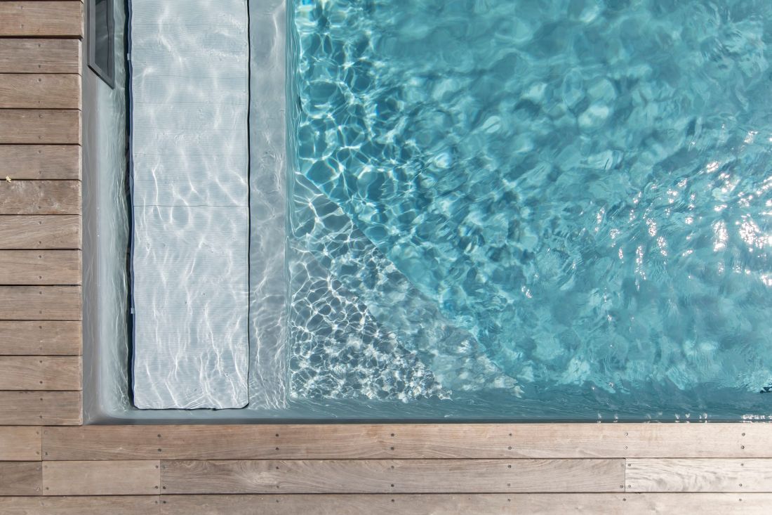 Couverture automatique de piscine de sécurité immergée sous banquette ouverte.