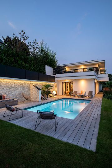 The house and night pool are almost unreal like a figment of the imagination or a synthetic image…