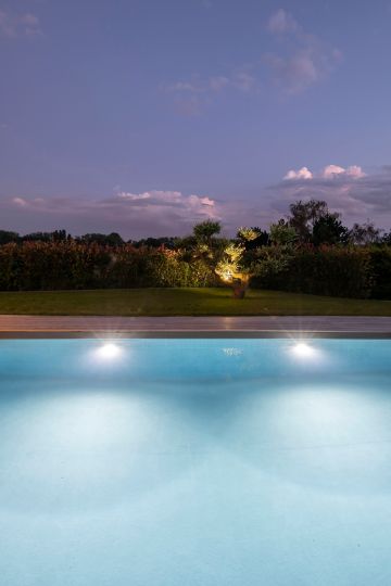 L'eau, le végétale, un éclairage simple et un ciel qui s'éteint... l'espace piscine est vivant et apaise le spectateur passé par là.