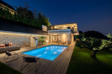 Une piscine enterrée de nuit intégrée à un projet piloté conjointement avec un cabinet d'architecture.