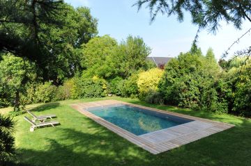 Cr7 au milieu d'une pelouse avec un simple de tour de piscine en bois.