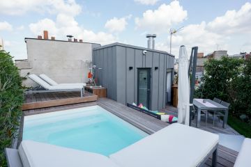 The roof terrace is accessed via a spiral staircase. The extension with zinc cladding is designed to echo the surrounding Paris rooftops.