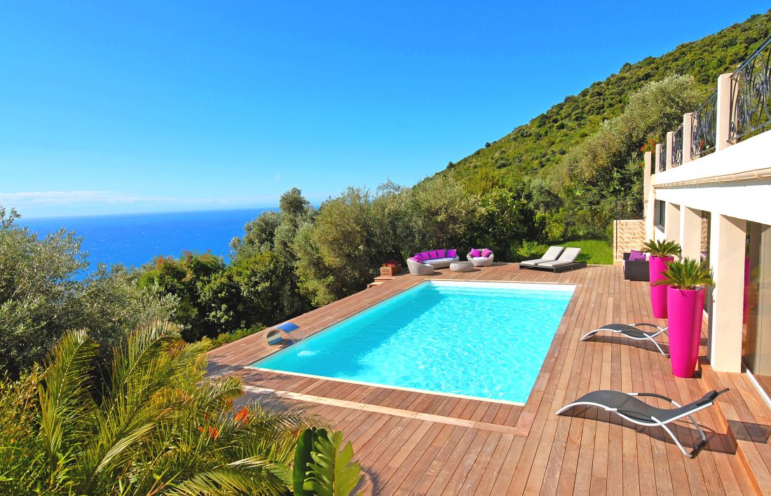 Grande piscine vue mer avec une eau couleur lagon grâce à son liner blanc.