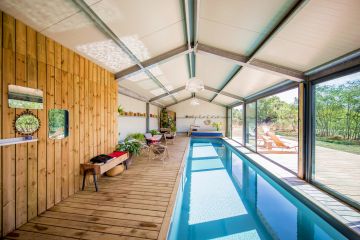 Wide patio doors are positioned along the edge of this extremely well-lit indoor lap pool, opening out onto the Anjou countryside and letting in abundant spring sunshine.