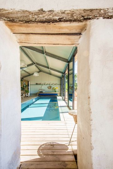 The room housing the swimming pool is separated from the old wing of the house by a thick wall whose rustic look gives the scene incredible charm.