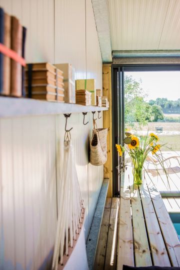 Quelques détails soignés et simples comme de vieux livres, un panier tressé et un bouquet de tournesols sont le décor de cette piscine en pays angevin.