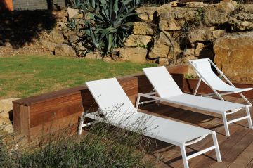 Quelques bains de soleil attendent calmement que les baigneurs viennent se détendre après la natation dans la piscine.