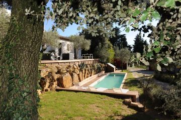 Cette piscine de charme trouve sa place au milieu d'une belle végétation de chênes et d'oliviers.