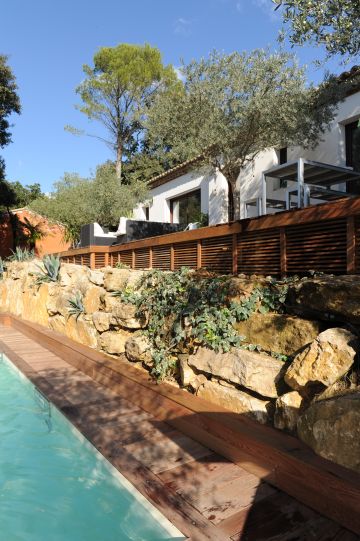 La maison d'architecte toute blanche et rythmée par les larges baies vitrée surplombe la piscine.