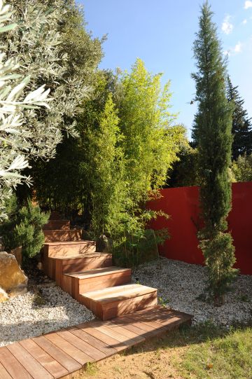 Les abords directs de la piscine ont été réalisés avec de la terrasse en ipé de même que les escaliers qui permettent de rejoindre le niveau supérieur où se situe la maison.