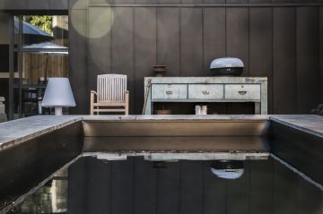 Comme s'ajoutant au mobilier extérieur, la piscine a été conçue dans ce projet comme un meuble design. Loin des clichés, elle est volontairement semi enterrée et drapée d'un liner noir à l'effet déroutant.