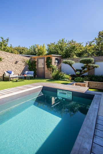 Au bout de la piscine un arbre taillé comme un grand bonsaï apporte de la majesté et de la sérénité à l'ensemble.