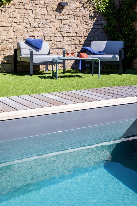 Stylish Fermob garden furniture set against a dry stone wall just metres from the pool.