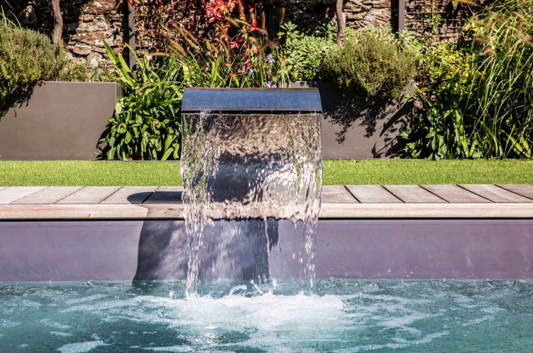 The Piscinelle stainless steel water curtain adds a designer feel to the pool.