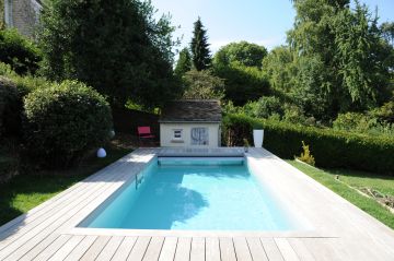 Une piscine Piscinelle Cr6 design et conviviale. Installée sur un terrain en terrasses elle surplombe la campagne environnante.