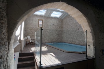 Piscine d'intérieur dans une cave voutée en pierre.