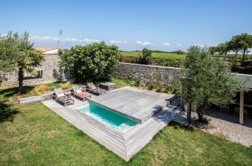 Une petite piscine enterrée équipée d'un Rolling-Deck, terrasse mobile de piscine imaginée par Piscinelle.