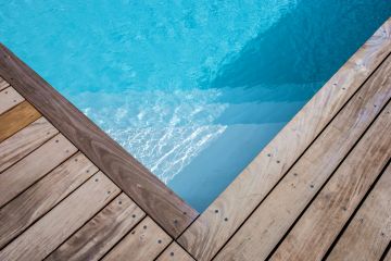 Le liner gris clair offre un plan d'eau lumineux qui fait varier les tons et les couleurs tout au long de l'année pour distraire chaque jour l'observateur de cette piscine traditionnelle en aluminium en Belgique.