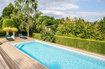 A crystal-clear pool on the outskirts of Brussels with a white liner.