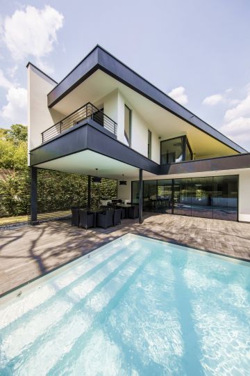 The white swimming pool liner echoes the white walls of the house and the taut lines of the 3-step Escabanc mirror the building's multiple convergence lines.