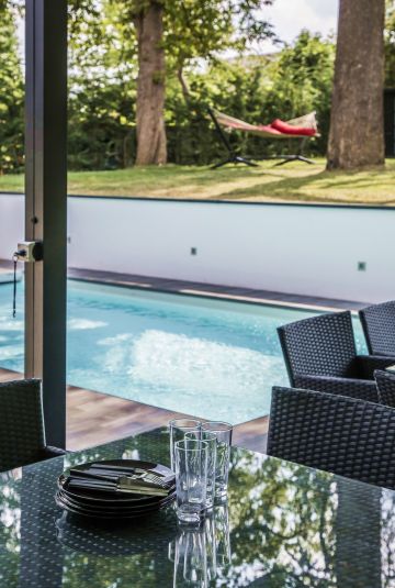 Reflections, with the discreet, minimalist, pool standing between a table set for lunch and a hammock.