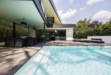 Eau, carrelage, métal, béton blanc, végétale... un esprit riche et protéiforme entoure cette piscine.