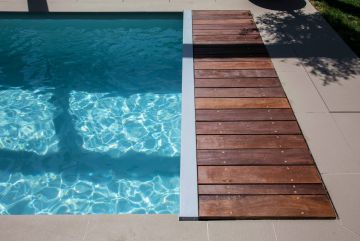 Beneath the wooden slats is an automatic pit-mounted cover securing the pool in seconds.