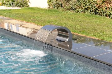 Piscine équipée d'une lame d'eau en inox et d'un liner gris granité.